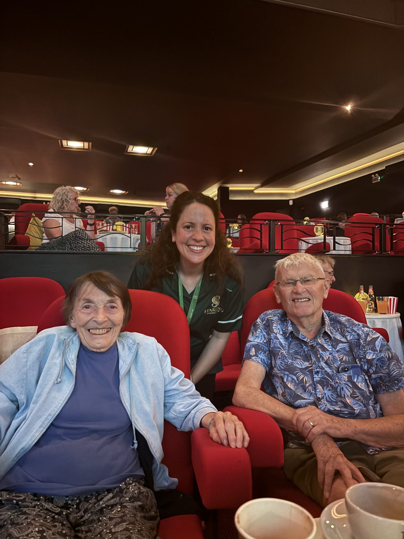 A Starling Homecare carer with two happy guests during a dementia-friendly cinema experience at the Odyssey Cinema in St Albans