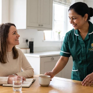 FND care at home, a Starling Homecare carer bringing a cup of tea to a woman in her kitchen