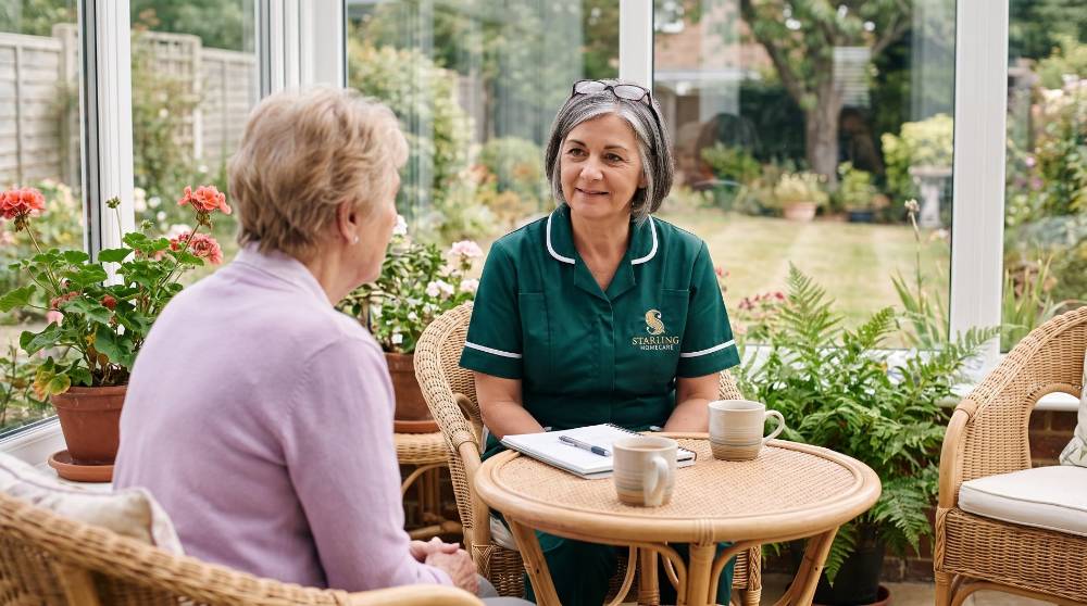 A Starling Homecare carer talking through home care or a care home in Hemel Hempstead with an older woman at her conservatory table