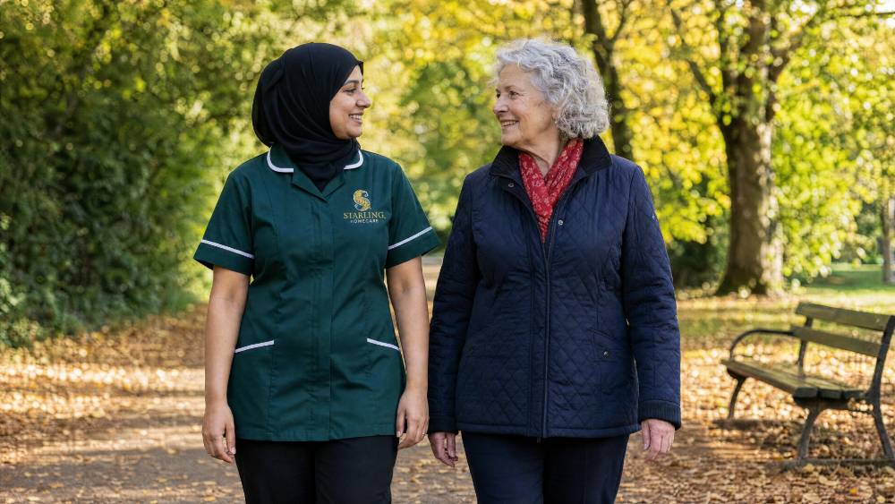 Carer in a bottle green uniform on an autumn walk with an older woman in Hatfield, dementia friendly exercise